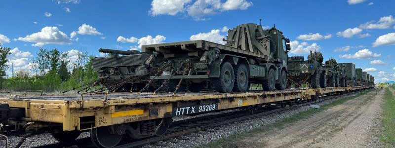 Open top railcars loaded with hi wide dimenstional military vehicles